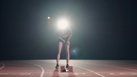 A-young-girl-is-standing-alone-at-the-track-and-field-stadium-and-is-preparing-for-the-race.-Preparation-for-the-sprint.-Concentration-and-psychological-preparation-for-competitions-in-slow-motion